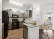 A kitchen with a refrigerator, oven, and sink